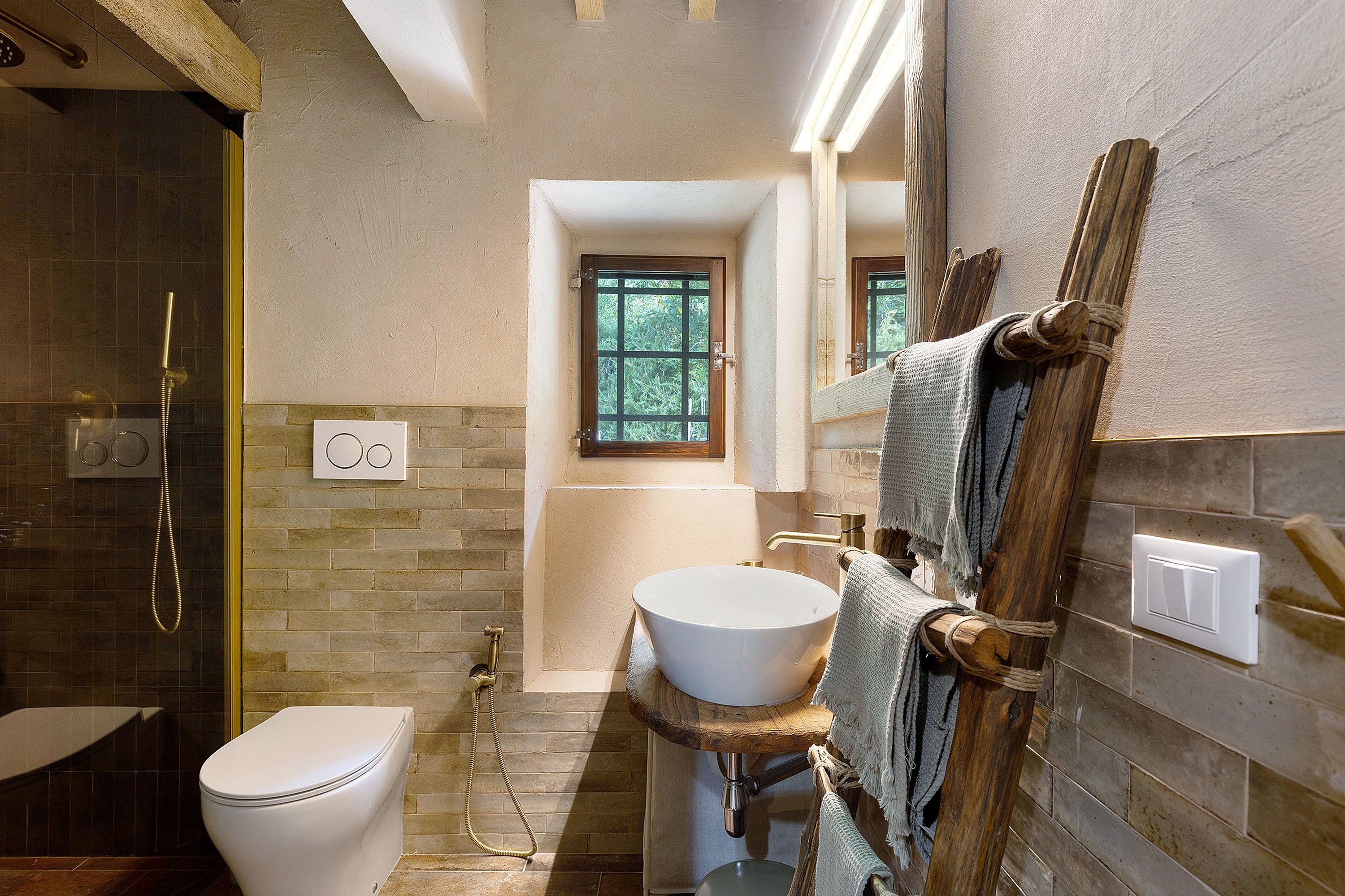 Ein Badezimmer mit Toilette, Waschbecken, Dusche und einem Fenster.