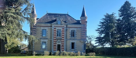 A large, historic building with a symmetrical facade, multiple windows, and two prominent towers.