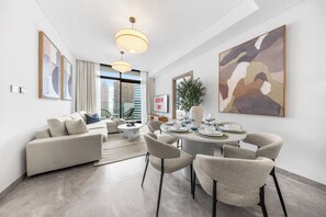 Una sala de estar moderna con sofá, mesa de comedor, sillas y obras de arte.