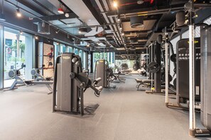 Ein Fitnessstudio mit unterschiedlichen Trainingsgeräten, großen Fenstern und modernem Design.