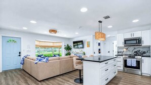 A modern kitchen with white cabinets, a black countertop, and stainless steel appliances. - NEW! Pool,  Pingpong, Foosball - Sleeps 10 (Largo)