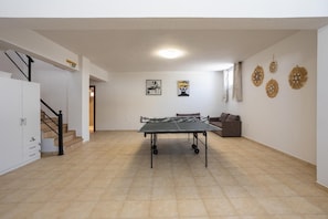 A spacious room with a ping pong table, a sofa, and decorative wall art. - Villa Starlight - Five Bedroom Villa, Sleeps 11 (Lardos)