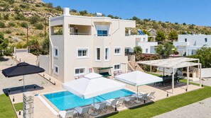A two-story building with a swimming pool, outdoor seating, and a covered patio area. - Villa Starlight - Five Bedroom Villa, Sleeps 11 (Lardos)