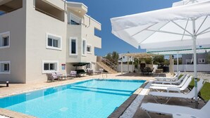 Un hôtel doté d’une piscine, de chaises longues et de parasols.