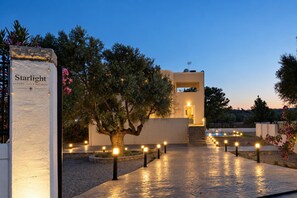A luxury villa retreat with a stone pathway, a large tree, and a building entrance. - Villa Starlight - Five Bedroom Villa, Sleeps 11 (Lardos)