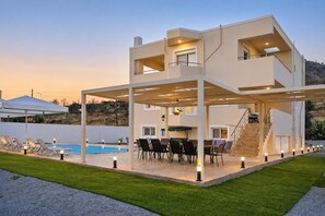 A modern two-story house with a covered outdoor area, a pool, and a staircase leading to the upper floor. - Villa Starlight - Five Bedroom Villa, Sleeps 11 (Lardos)
