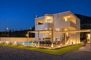 A modern two-story house with a swimming pool, outdoor seating, and a staircase leading to the upper level. - Villa Starlight - Five Bedroom Villa, Sleeps 11 (Lardos)