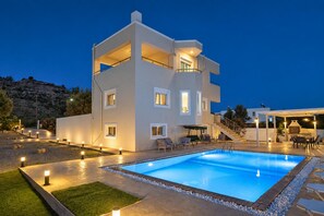 A modern multi-story building with a swimming pool, outdoor seating, and a staircase leading to the upper levels. - Villa Starlight - Five Bedroom Villa, Sleeps 11 (Lardos)