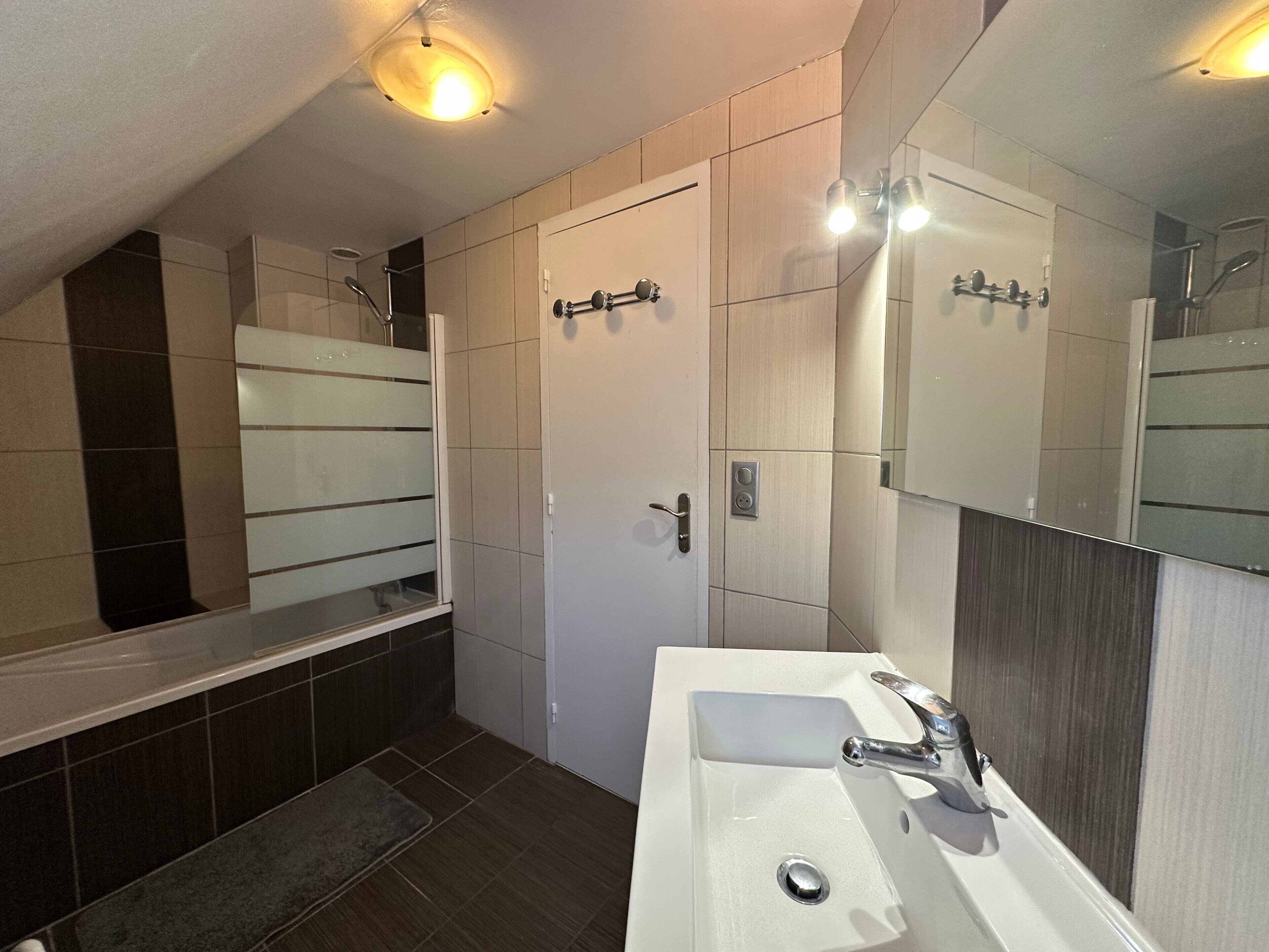 Une salle de bain moderne avec une baignoire, un lavabo et un miroir.