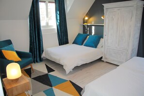 Ein Schlafzimmer mit einem Bett, einem Sessel, einem Kleiderschrank und einer Lampe.