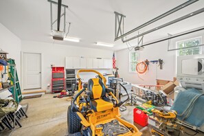 A workshop with various tools and equipment, including a yellow construction vehicle, a miter saw, and a power tool. - Boonsboro Escape (Lynchburg)