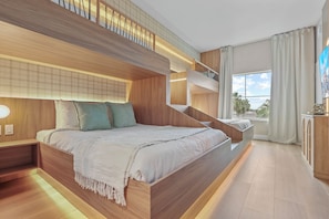A modern bedroom with a large bed, built-in shelving, and a view of the outdoors. - 1BR apartment with 2 queens near Disney (Orlando)