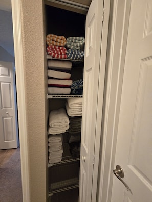 A closet with neatly folded towels and blankets. - Terrific Pool Home, close to Flagler Beach & Daytona (Palm Coast)