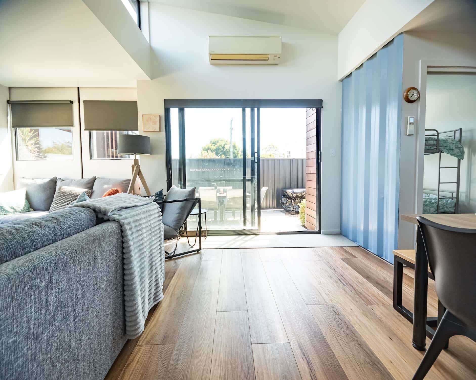 Un dormitorio moderno con una cama grande, un escritorio y un balcón.