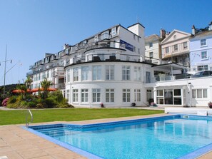 A white building with balconies and a swimming pool in front. - 4 The Salcombe (Salcombe)
