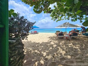 A beach with sun loungers, umbrellas, and a clear view of the ocean. - Poolside condo with garden access direct to beach! (Holetown)