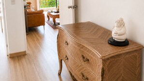 A room with a wooden chest of drawers, a small statue, and two framed artworks on the wall. - Deluxe Retreat Steps from Larcomar (Miraflores)