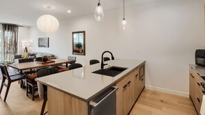A modern kitchen with a central island, built-in appliances, and pendant lighting. - 3BR/3.5BA Rooftop Home + Private Flat | Tennyson (Denver)
