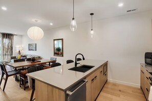 A modern kitchen with a central island, built-in appliances, and pendant lighting. - 3BR/3.5BA Rooftop Home + Private Flat | Tennyson (Denver)