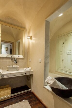 Un baño con lavamanos, espejo y bañera.