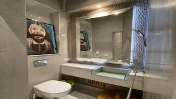 A bathroom with a modern design, featuring a toilet, sink, and mirror.