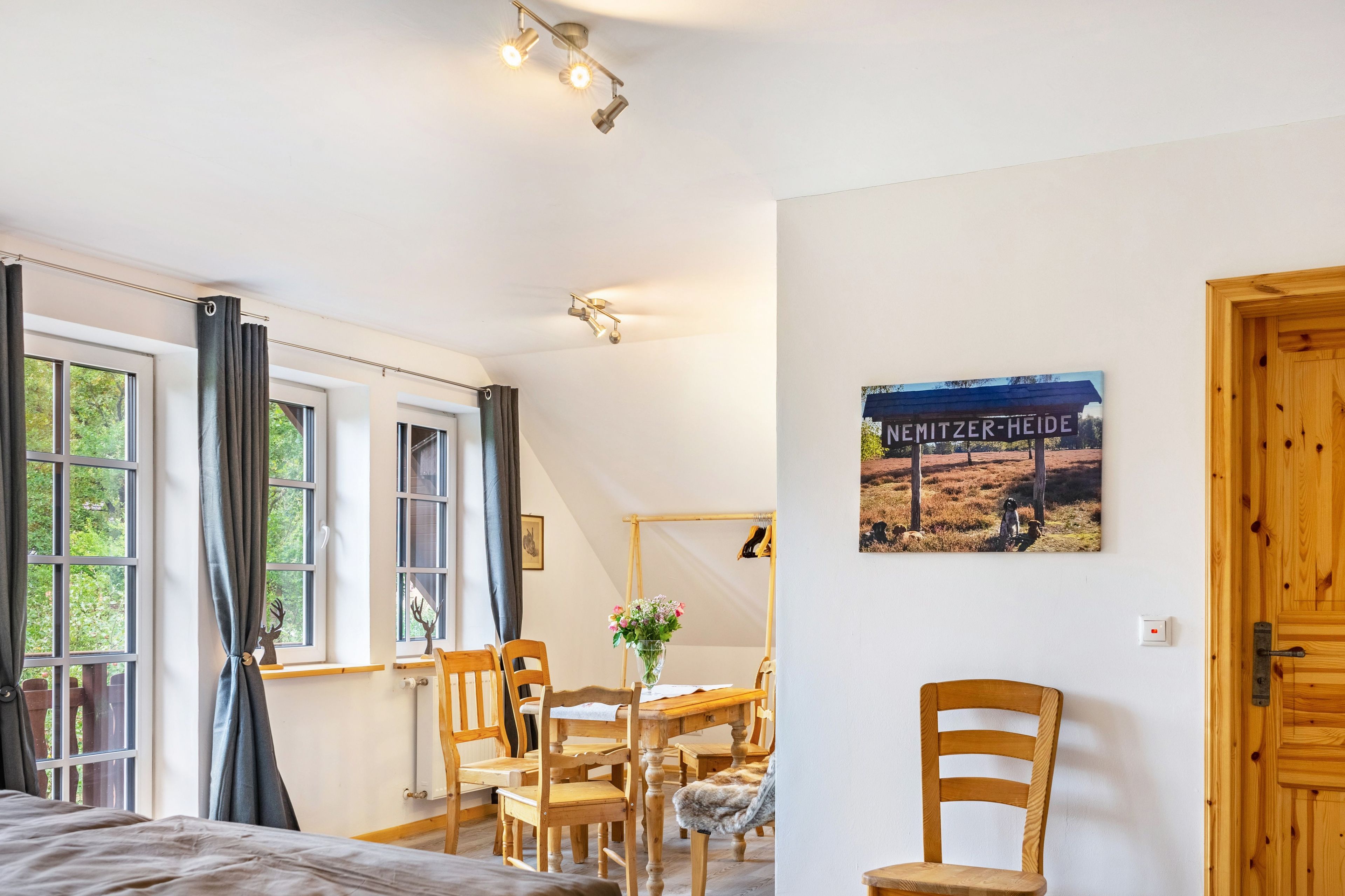Ein Zimmer mit einem Bett, einem Tisch mit Stühlen, einem Heizkörper und einem Bild an der Wand.