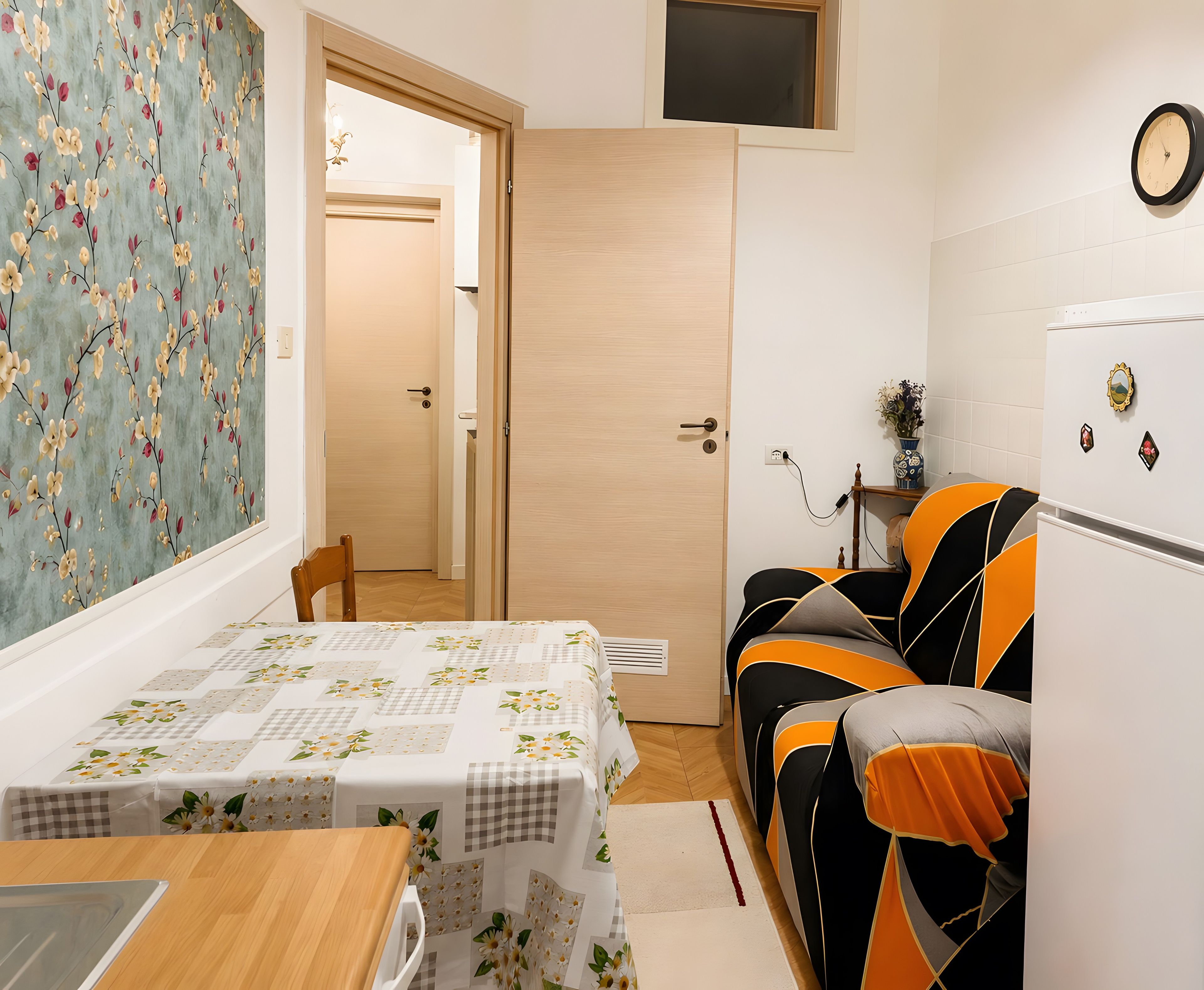 A compact living space with a dining area, a sofa, a small table, and a kitchenette.