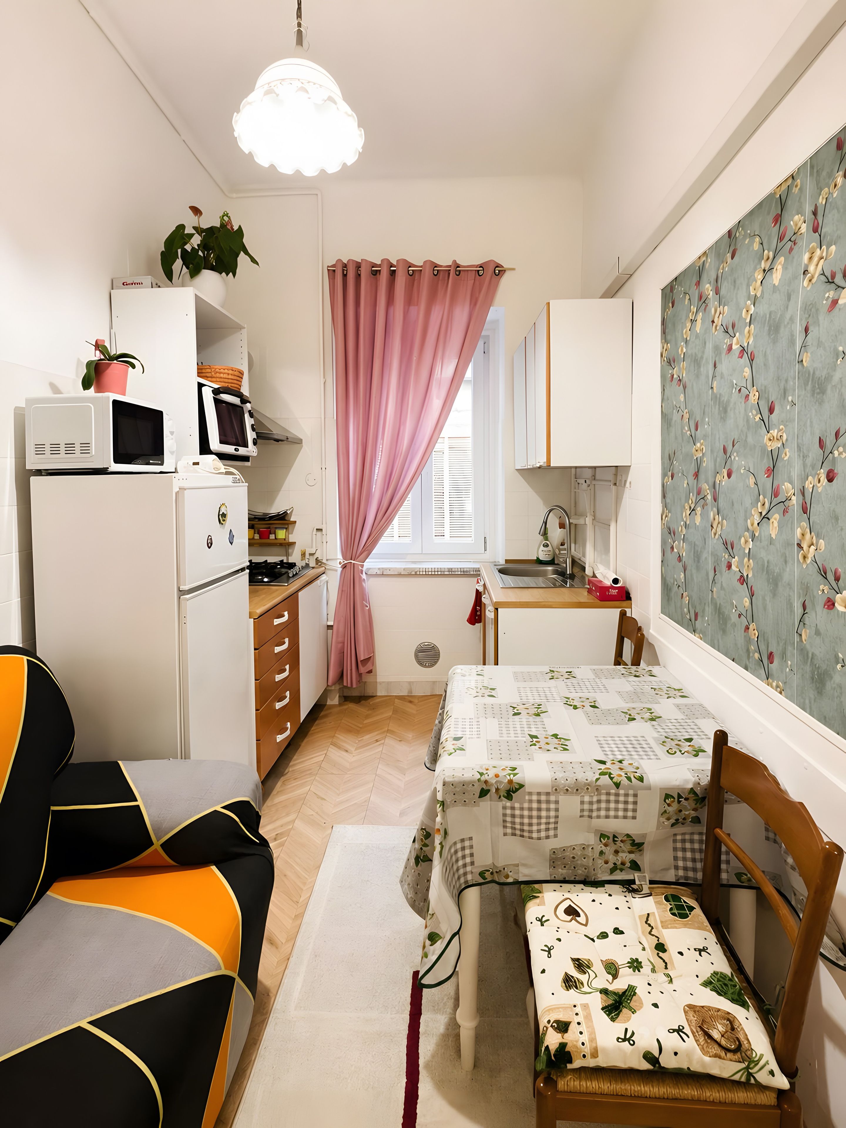 Eine kleine Küche mit Kühlschrank, Mikrowelle und Spüle.