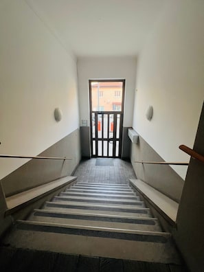 Un escalier menant à une porte qui donne sur un bâtiment situé à l’extérieur.