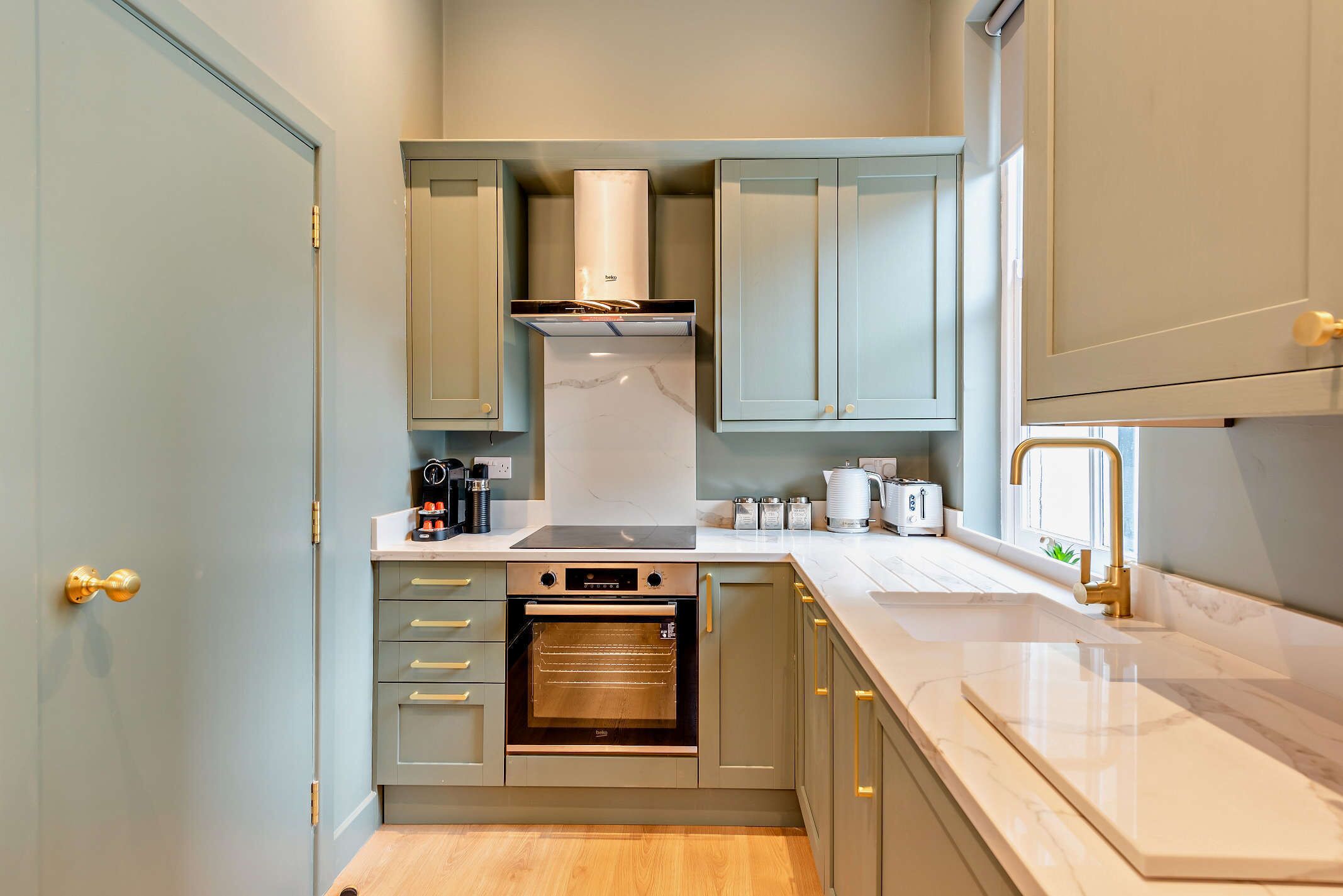 A compact kitchen with a built-in oven, a coffee maker, and a toaster.