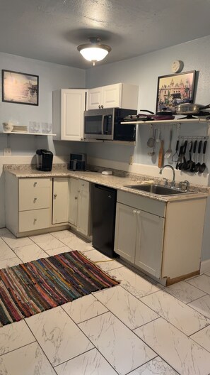 A compact kitchen with white cabinets, a microwave, a dishwasher, and a sink. - Private Sarasota Guest House Near Beaches, Downtown & Siesta Key (Sarasota)