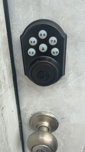A door lock with a numeric keypad and a keyhole.