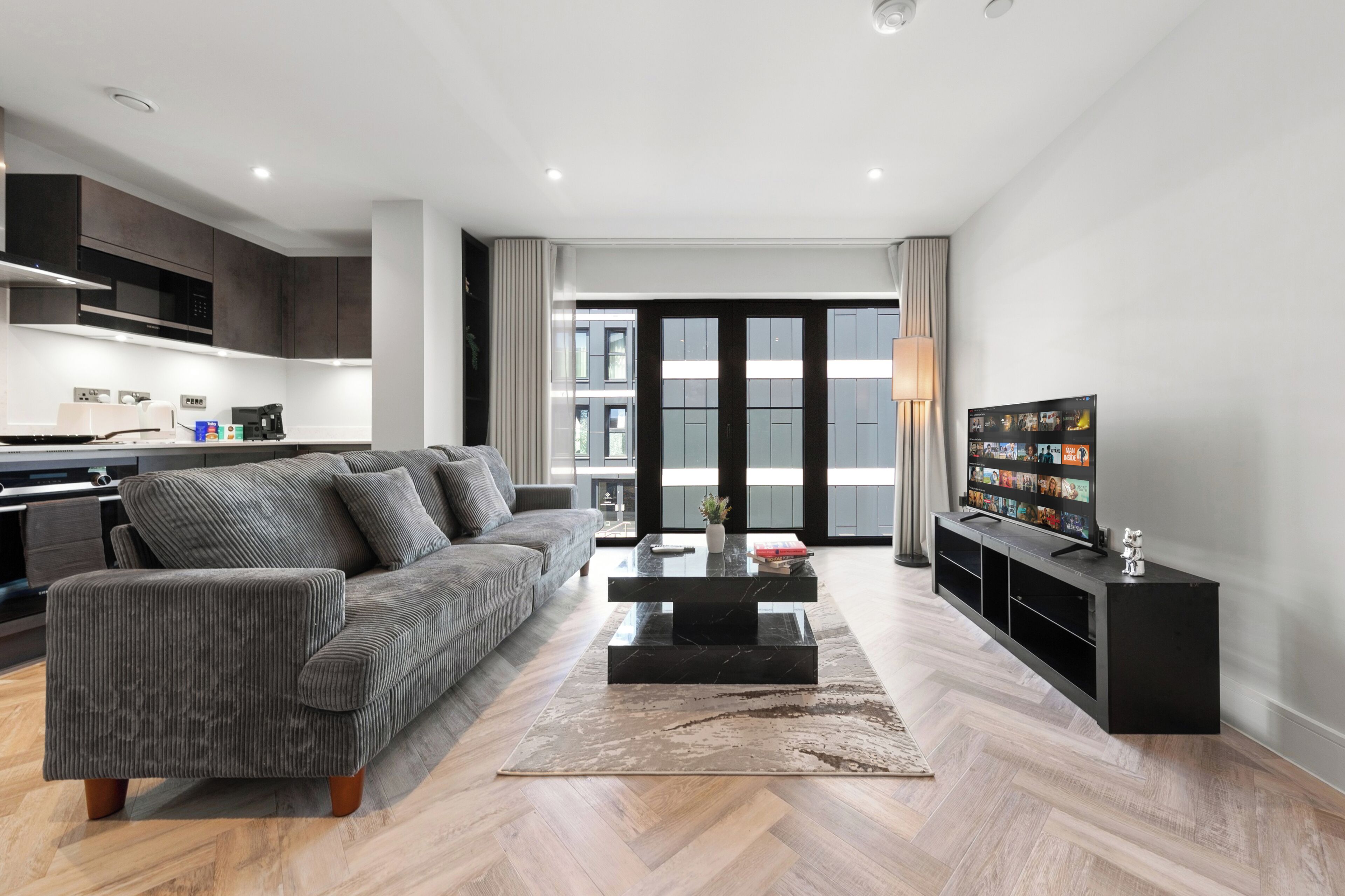 Una sala de estar moderna con sofá, mesa de centro y televisión.