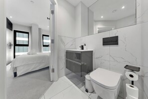 Ein modernes Badezimmer mit Toilette, Bidet und Waschbecken.
