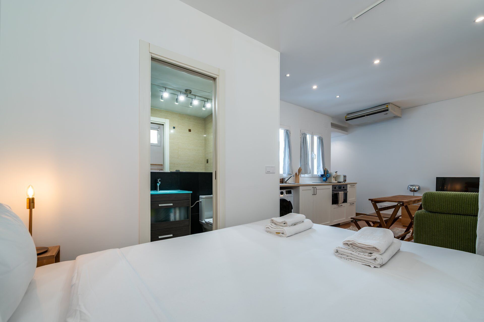 Une chambre d’hôtel équipée d’un lit, d’une petite kitchenette, d’un miroir et d’un téléviseur.