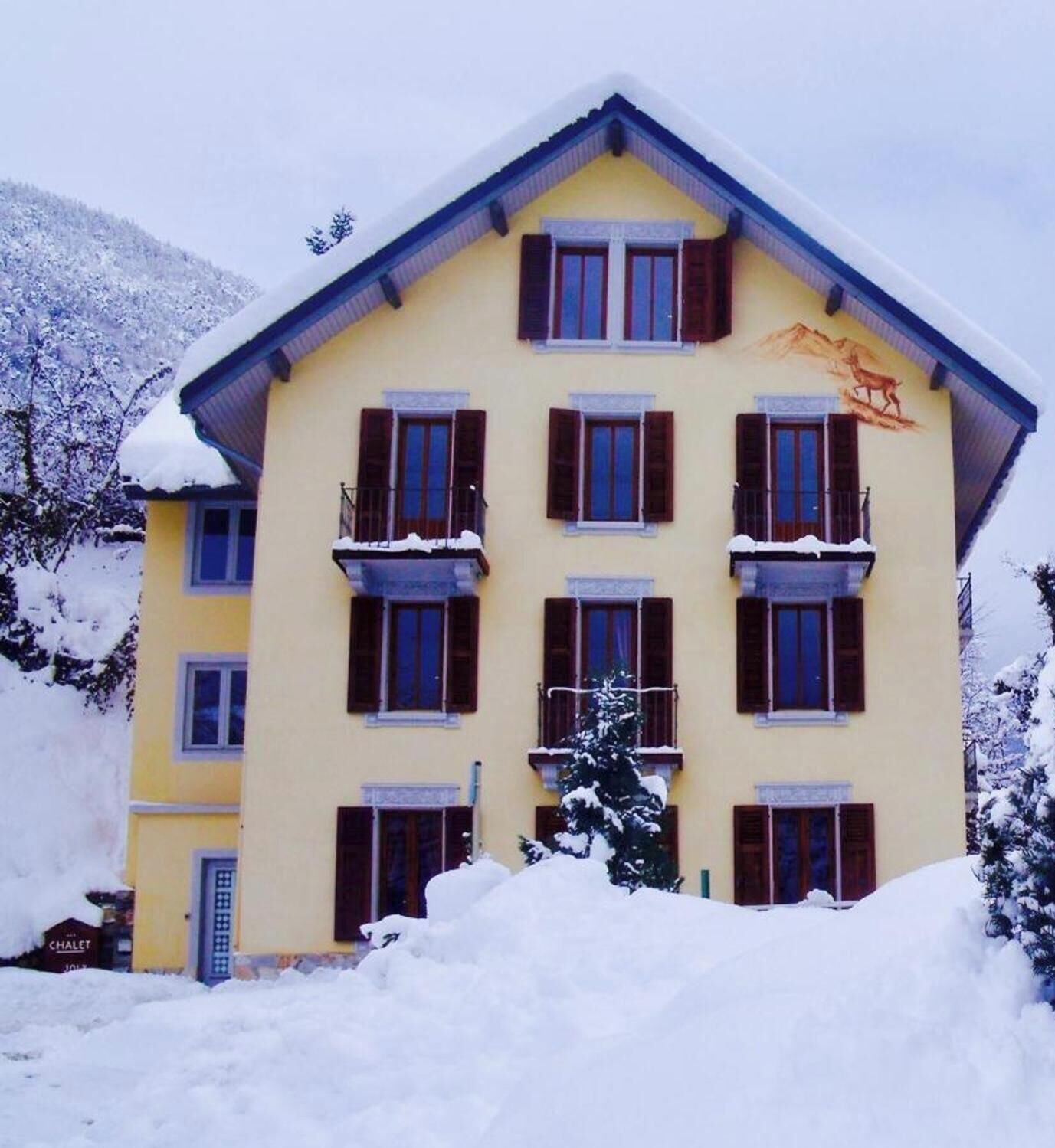 Un edificio de varios pisos con techo nevado y balcones.