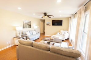 A spacious living room with a sofa set, a coffee table, and a television. - Welcome to The Hickory Cottage, a charming coastal retreat in Bay St. Louis (Bay St. Louis)