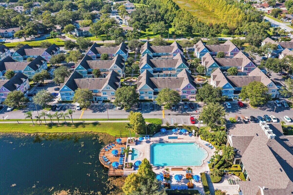 A residential area with multiple houses, a swimming pool, and a parking lot.