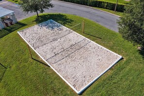 A rectangular outdoor area with a sandy surface, surrounded by grass and a paved road. - Venetian Bay Resort Townhouse w/ Pool & Gym Access (Kissimmee)