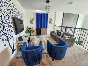 A living room with a sofa, two armchairs, a TV, and a staircase. - Villa w/ Private Pool, Near Disney - Champions (Davenport)