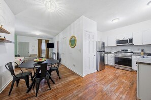 A compact kitchen with white cabinets, a stainless steel refrigerator, and a microwave. - Affordable and Close to the City Townhome! (Atlanta)