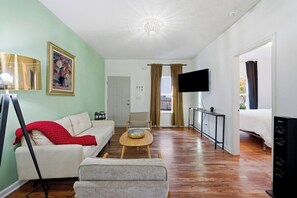 A room with a sofa, a chair, a television, and a bed. - Affordable and Close to the City Townhome! (Atlanta)