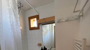 A small bathroom with a shower, a sink, and a mirror. - Valfréjus – 6 people – Skiing & panoramic views (Modane)