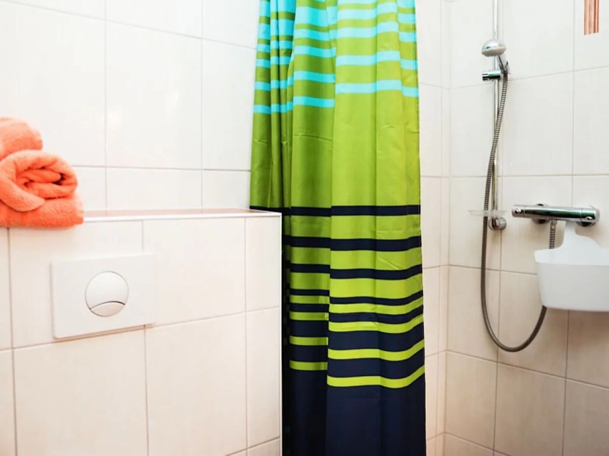 Ein Badezimmer mit Dusche, Handtuch und Vorhang.