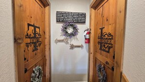 Un passadís amb portes de fusta amb el nom de 'Thyme' i 'Lavender', un senyal de direcció i una corona penjada a la paret.
