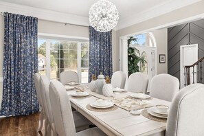 A dining room with a table set for six, large windows, and a chandelier. - Wake. Lakeview. Repeat. Luxury Holiday Getaway (Fayetteville)