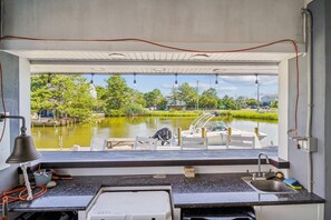 Eine Küche mit Seeblick, einem angedockten Boot und einer Sitzgelegenheit im Freien.