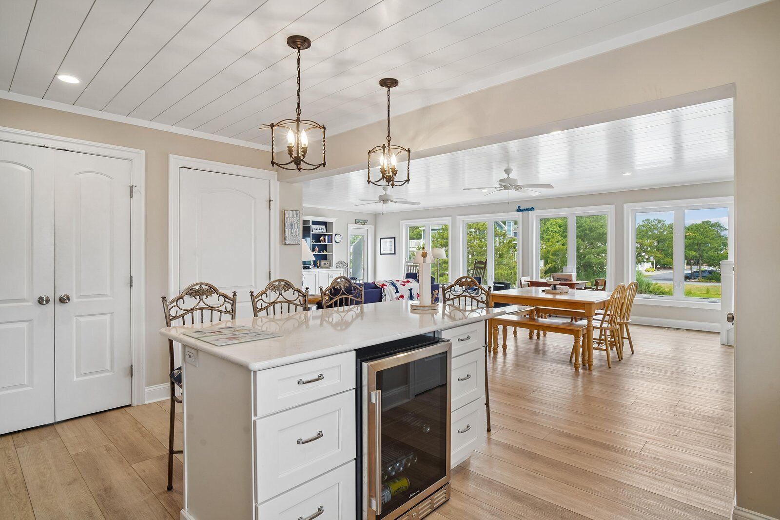 A spacious kitchen with a large island, wooden chairs, and a dining area with a view.