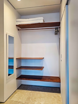 A narrow hallway with built-in wooden shelves, a white door, and a small window. - Casa Geller (Ipojuca)