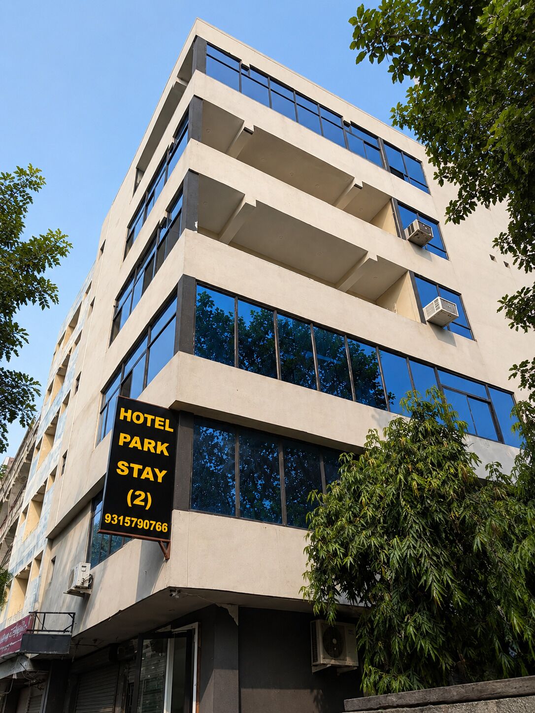 Un edificio de hotel de varios pisos con un letrero que indica estadía en el parque hotel.